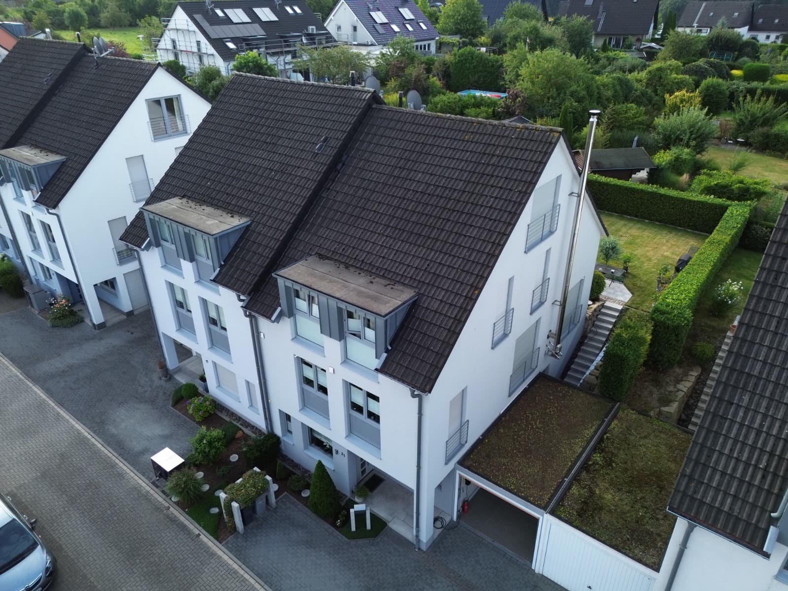 Steiles, komplexes Dach mit Gauben und alten, bemoosten Ziegeln